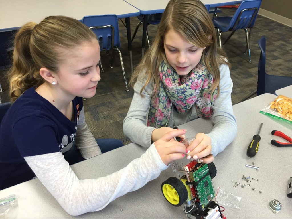 Madison and Kelsey hacking a sensor mount to work with a Raspberry Pi camera.